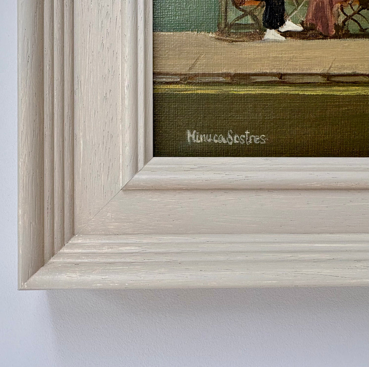 Close-up of the white wooden frame and signature on the original Baker Boxcar oil painting by Minuca Sostres.
