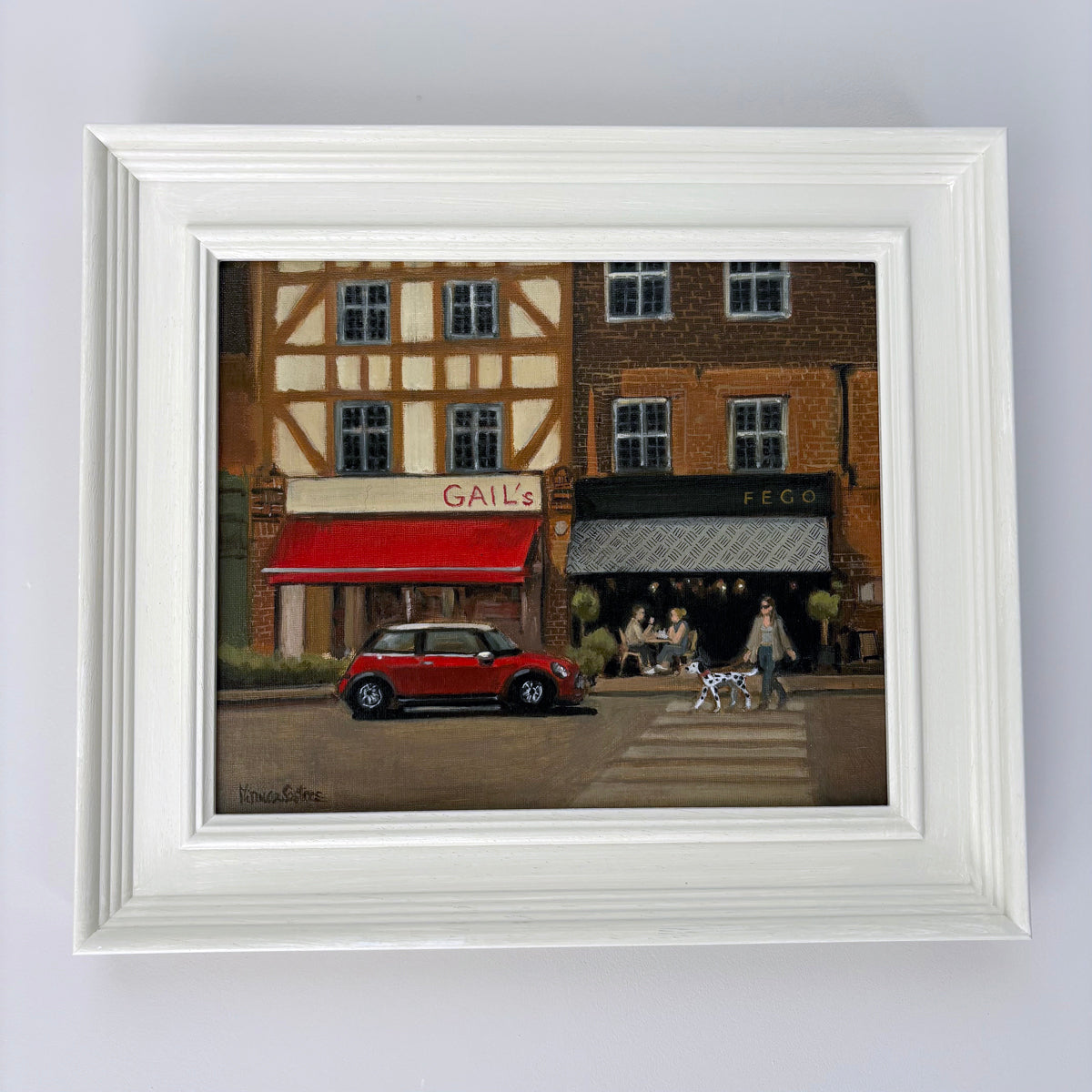 Original oil painting of Esher, Surrey, by Minuca Sostres, featuring Gail's Bakery, Fego café, a classic red Mini Cooper and a morning village street scene.