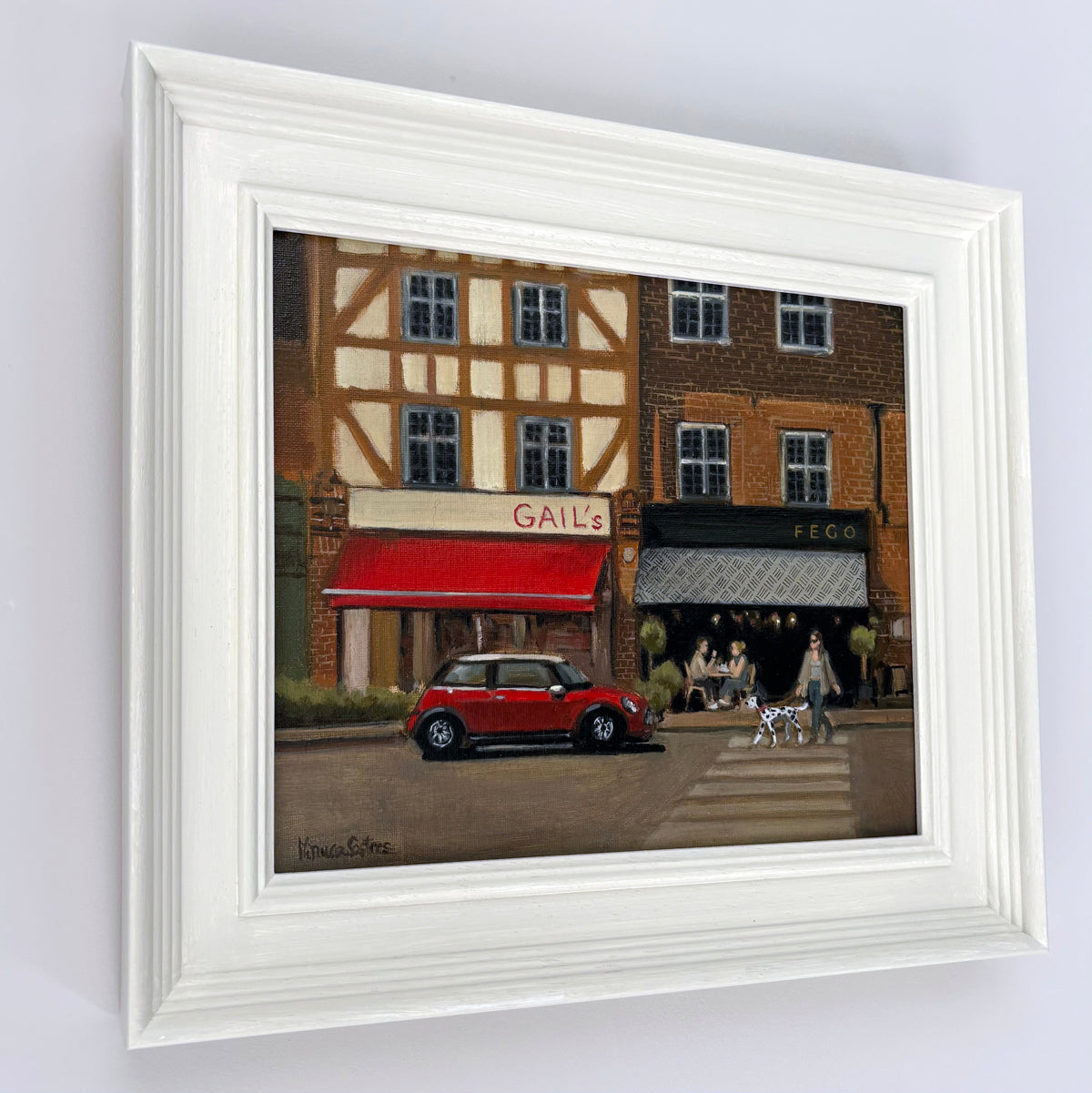 Original oil painting of Esher, Surrey, by Minuca Sostres, featuring Gail's Bakery, Fego café, a classic red Mini Cooper and a morning village street scene.