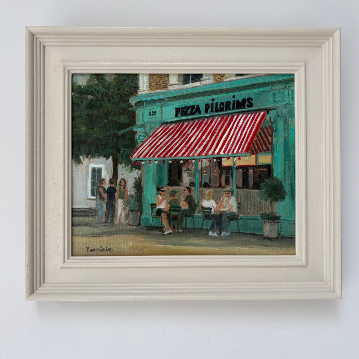 Framed oil painting of Pizza Pilgrims by Minuca Sostres, showing its turquoise storefront, red-and-white striped awning and people seated outside.